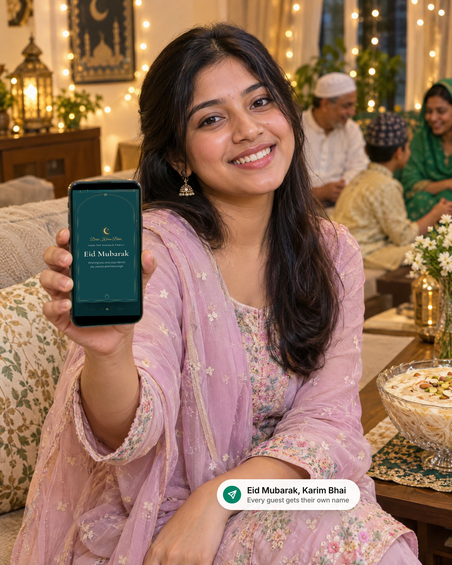 A smiling young woman at a family Eid gathering holding up a phone with a personal Eid Mubarak card